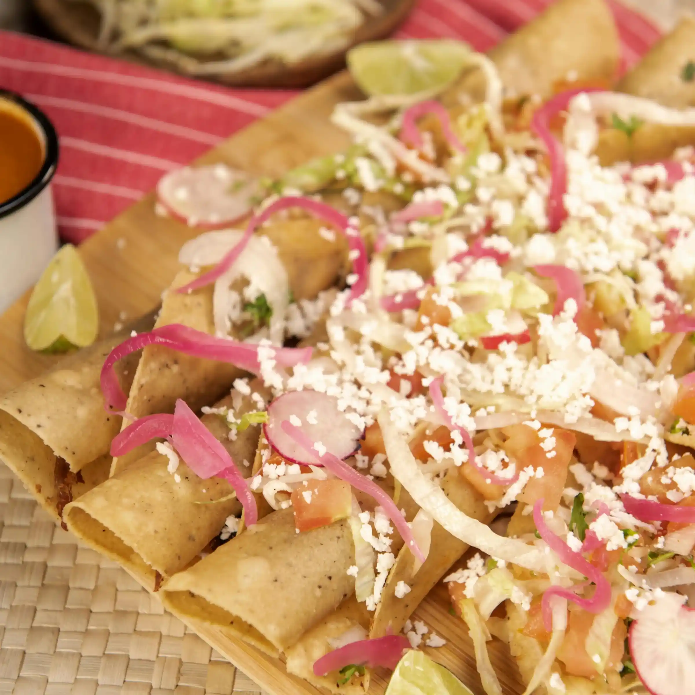 Close up shot of fresh tasty taquitos topped off with fresh, homemade ingredients.