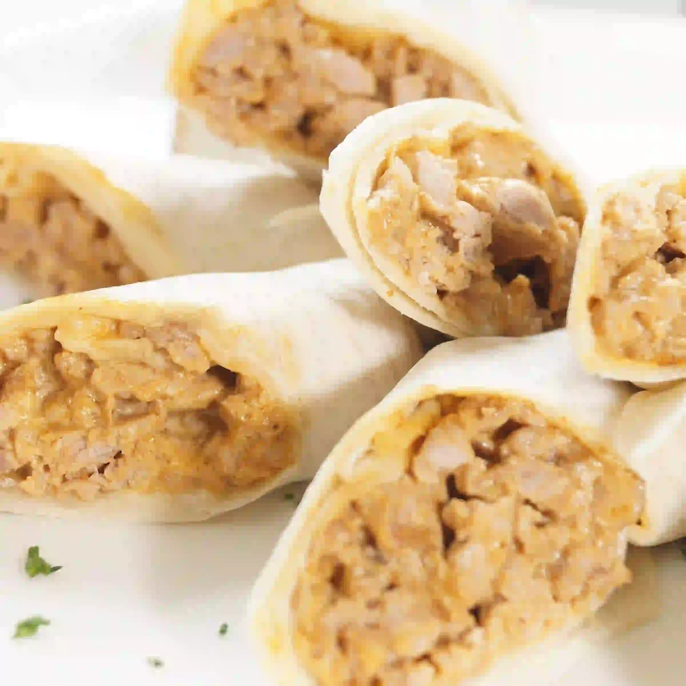 Zoomed in shot of various stuffed taquitos pointing towards camera.