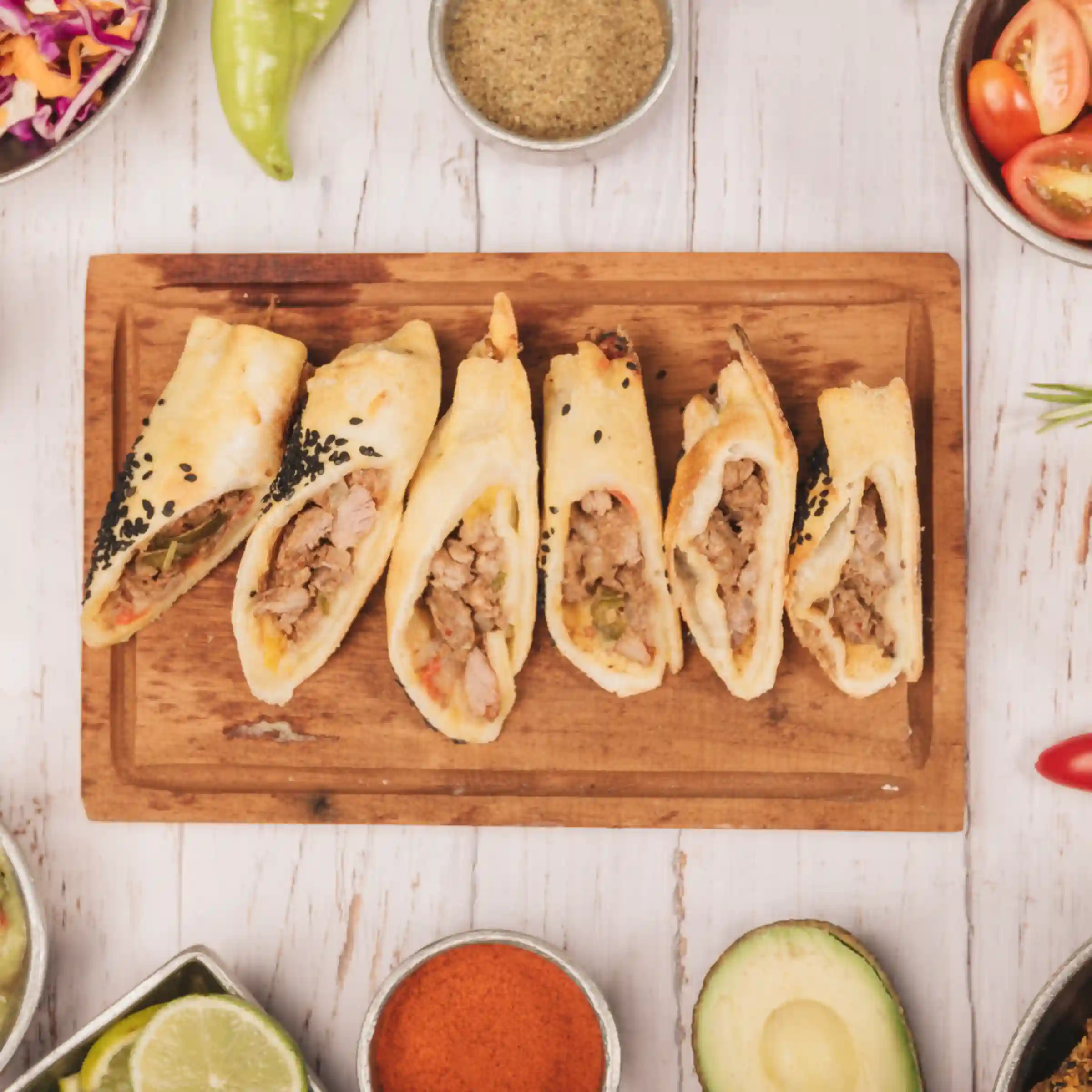 Top angle view of a platter of six taquitos on wooden surface